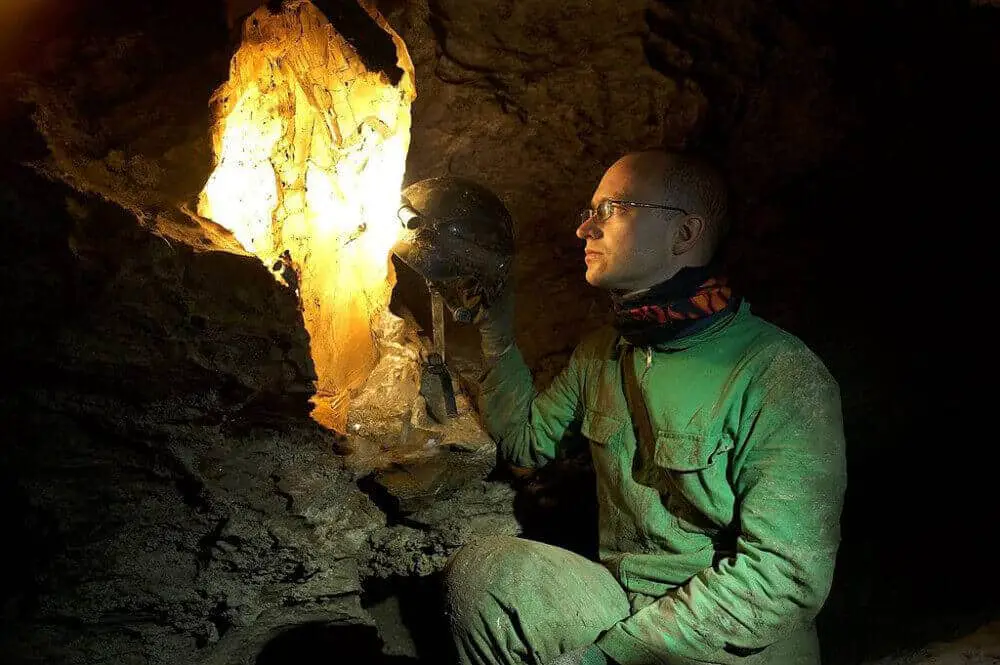 A speleologist highlights a gypsum crystla