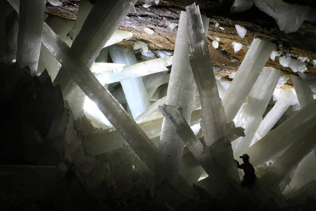 Huge crystal formations in cave with small man