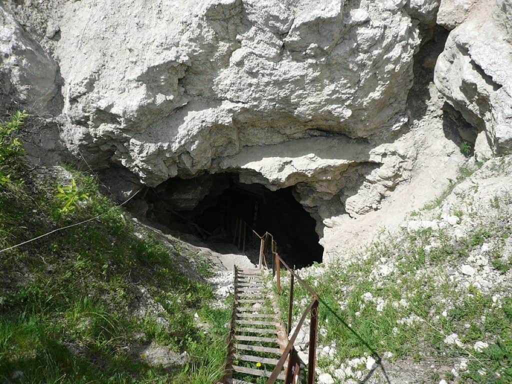 Huge cave entrance in white gypsum with stairs