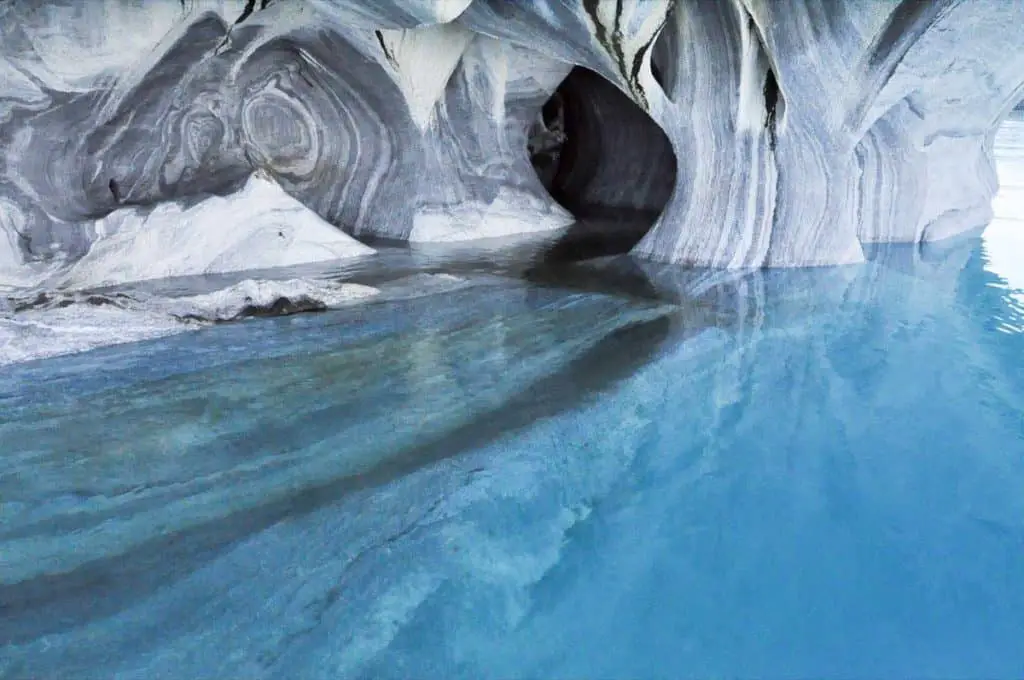 Cave with bright blue water and white and yellow streaks