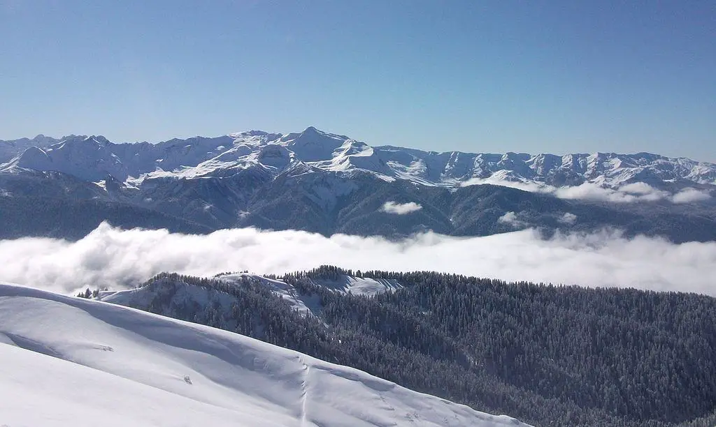 Birds eye view on Arabika Massif, with clouds and mountaintops and snow