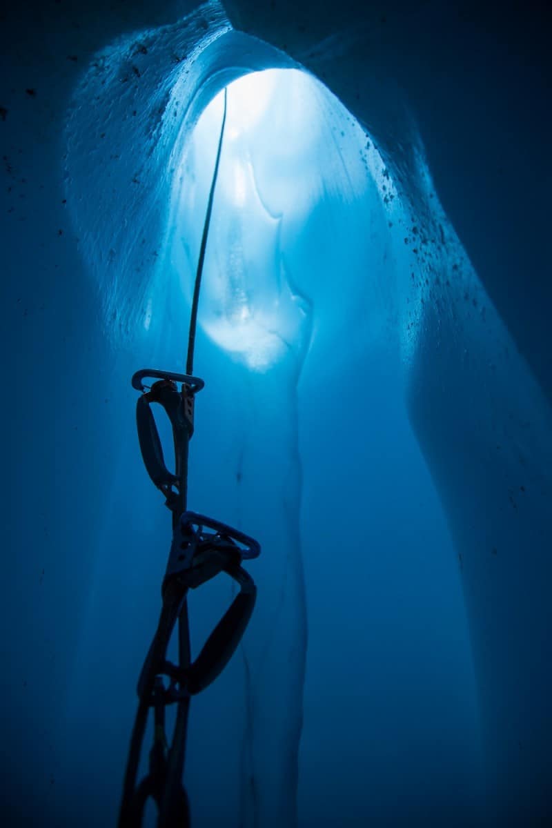 Looking up rope with ascenders from inside a deep moulin ice cave
